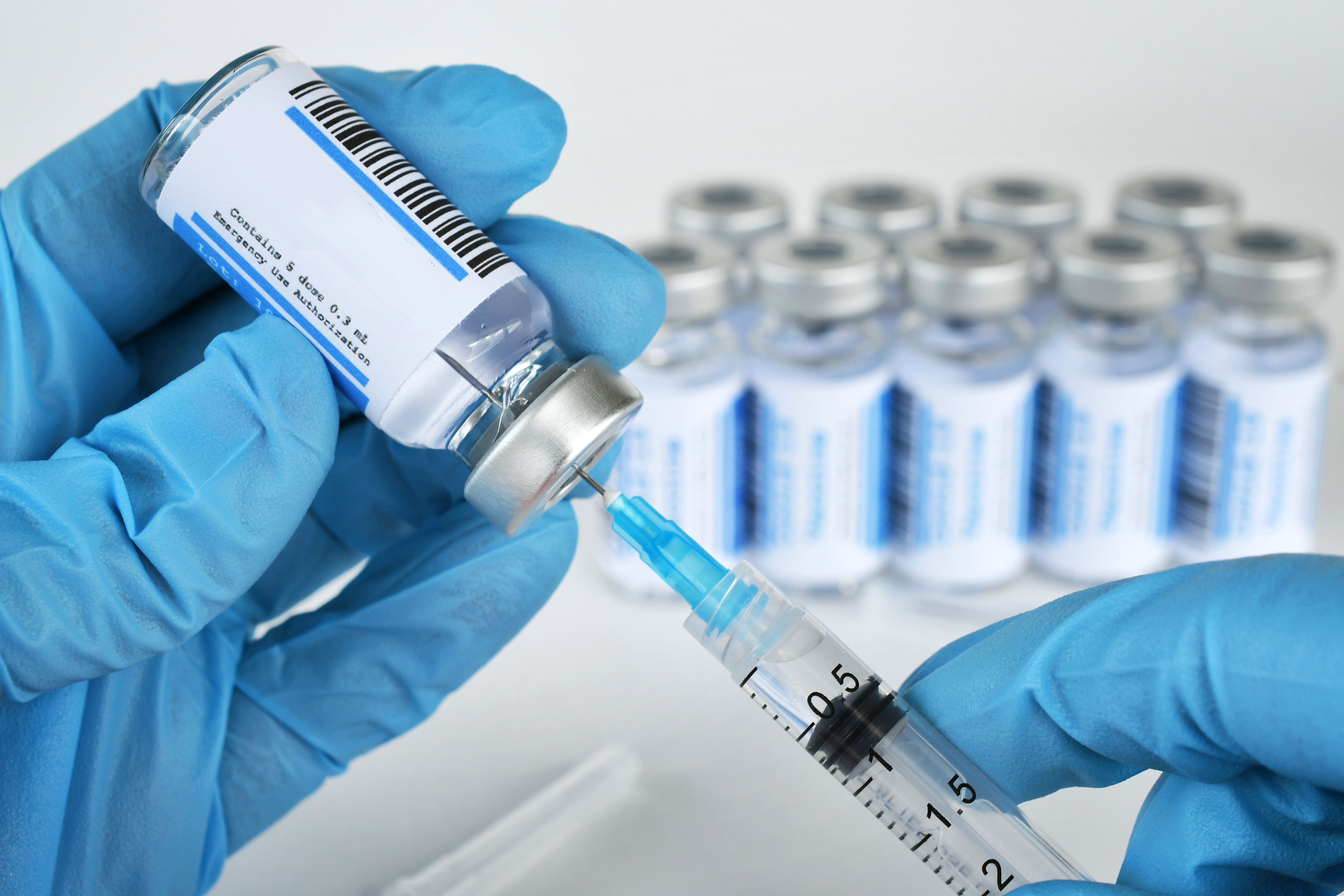 Health care worker filling a syringe needle