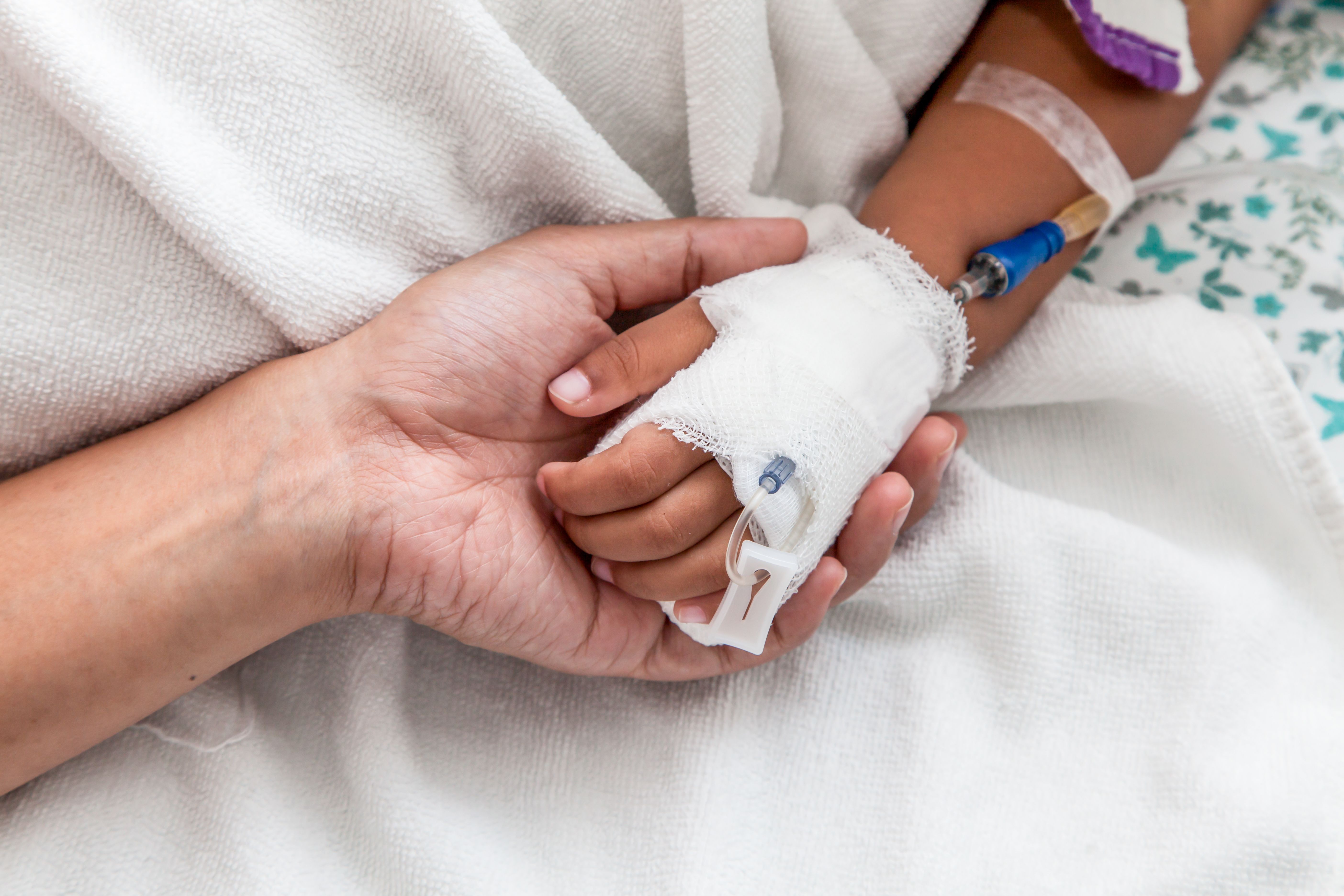 Adult holding hand of child with cancer | Image Credit: © pingpao - stock.adobe.com