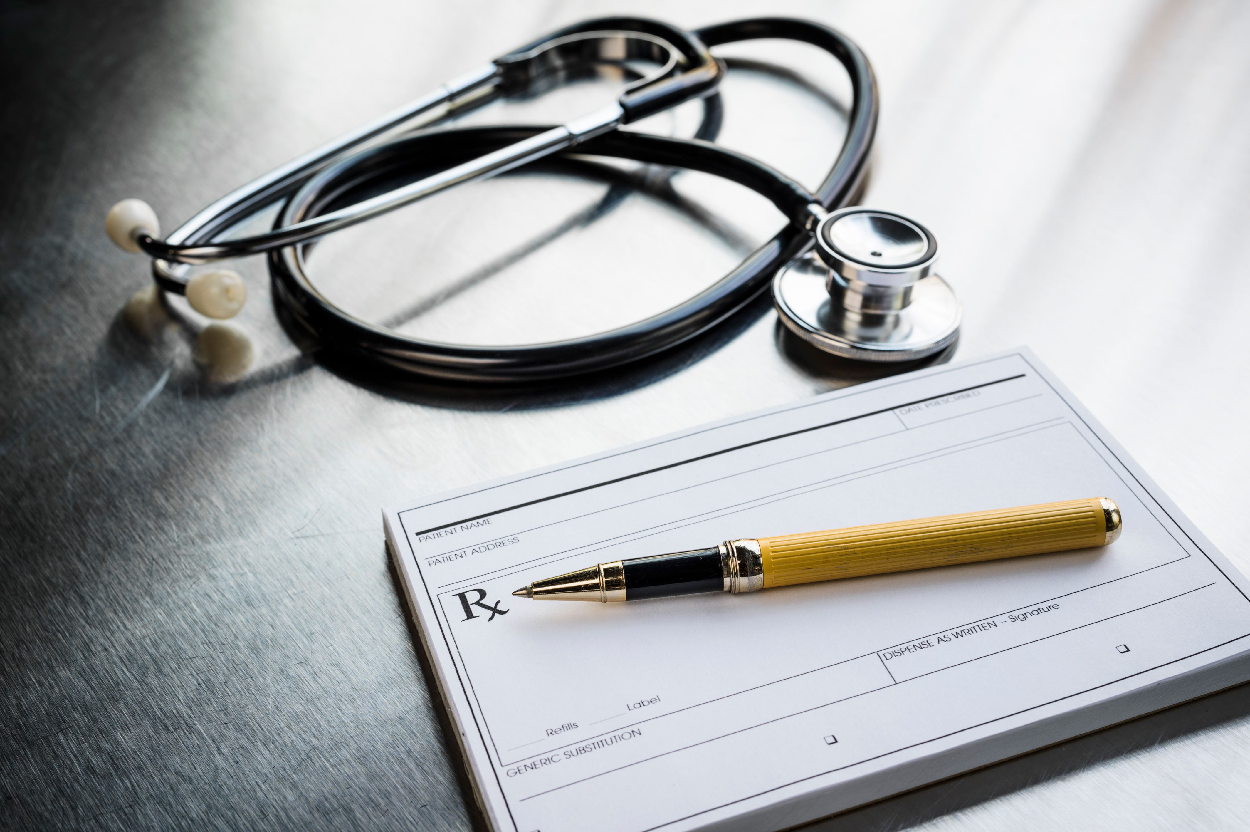 Prescription pad and a stethoscope on a desk