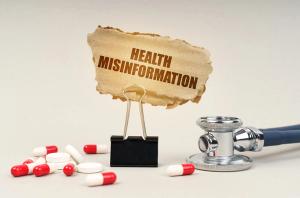Stethoscope and pills around a clip with a health misinformation cardboard sign | Image Credit: © Dzmitry - stock.adobe.com