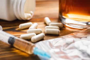 White pills, syringe with a drugs dose, narcotics, glass with alcohol drink on a wooden table, close-up view. Concept of addiction and bad habits - Image credit: O.Farion | stock.adobe.com