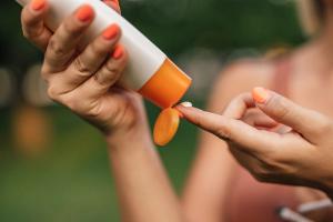 Close-up image of a woman putting on sun lotion | Image Credit: ©  bnenin - stock.adobe.com