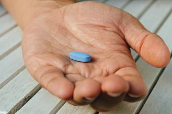 Man holding viagra pill -- Image credit: PaulSat | stock.adobe.com