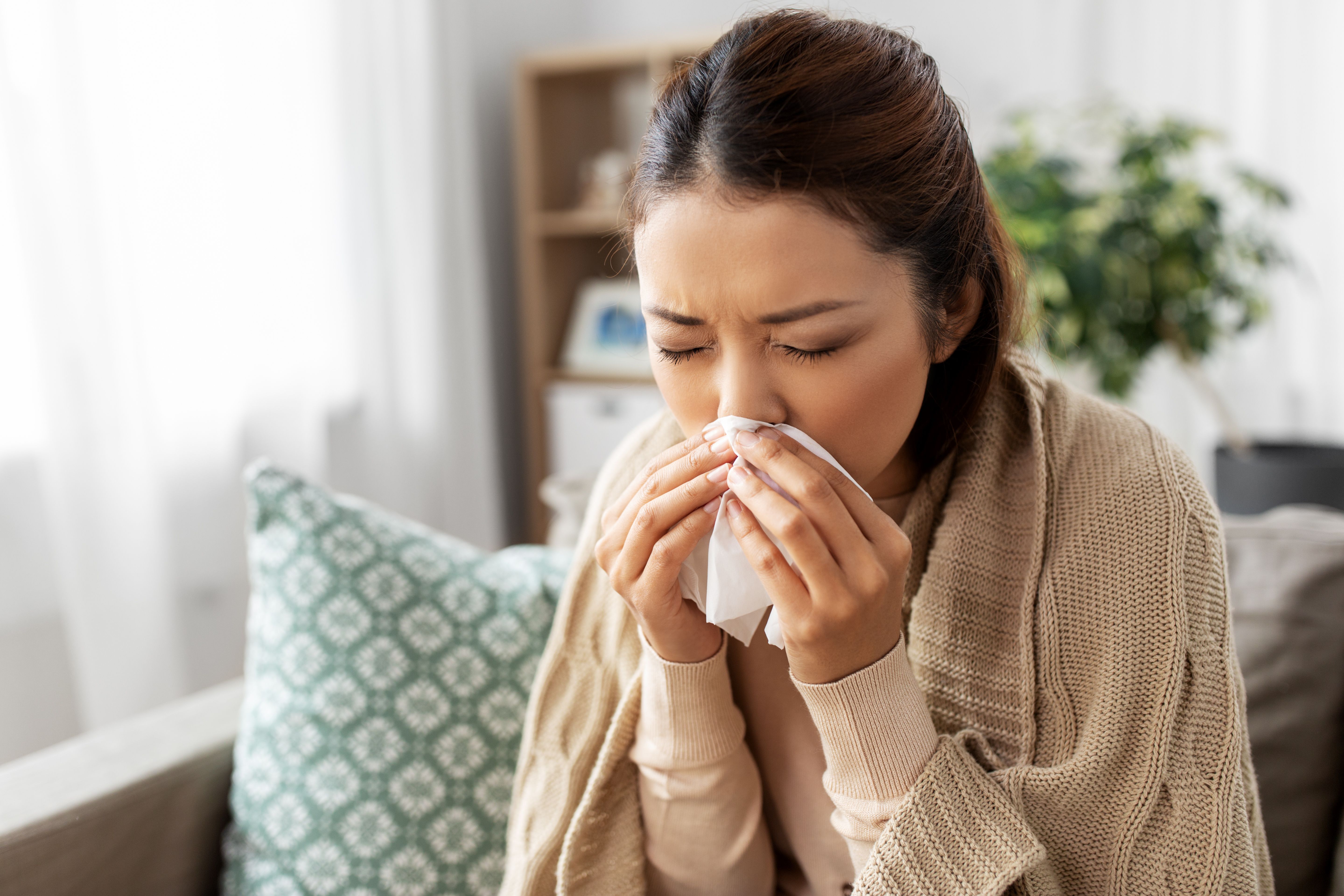 Woman blowing nose into a tissue | Image Credit: © Syda Productions - stock.adobe.com