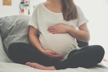 Pregnant woman touching her belly | Image Credit: SianStock - stock.adobe.com