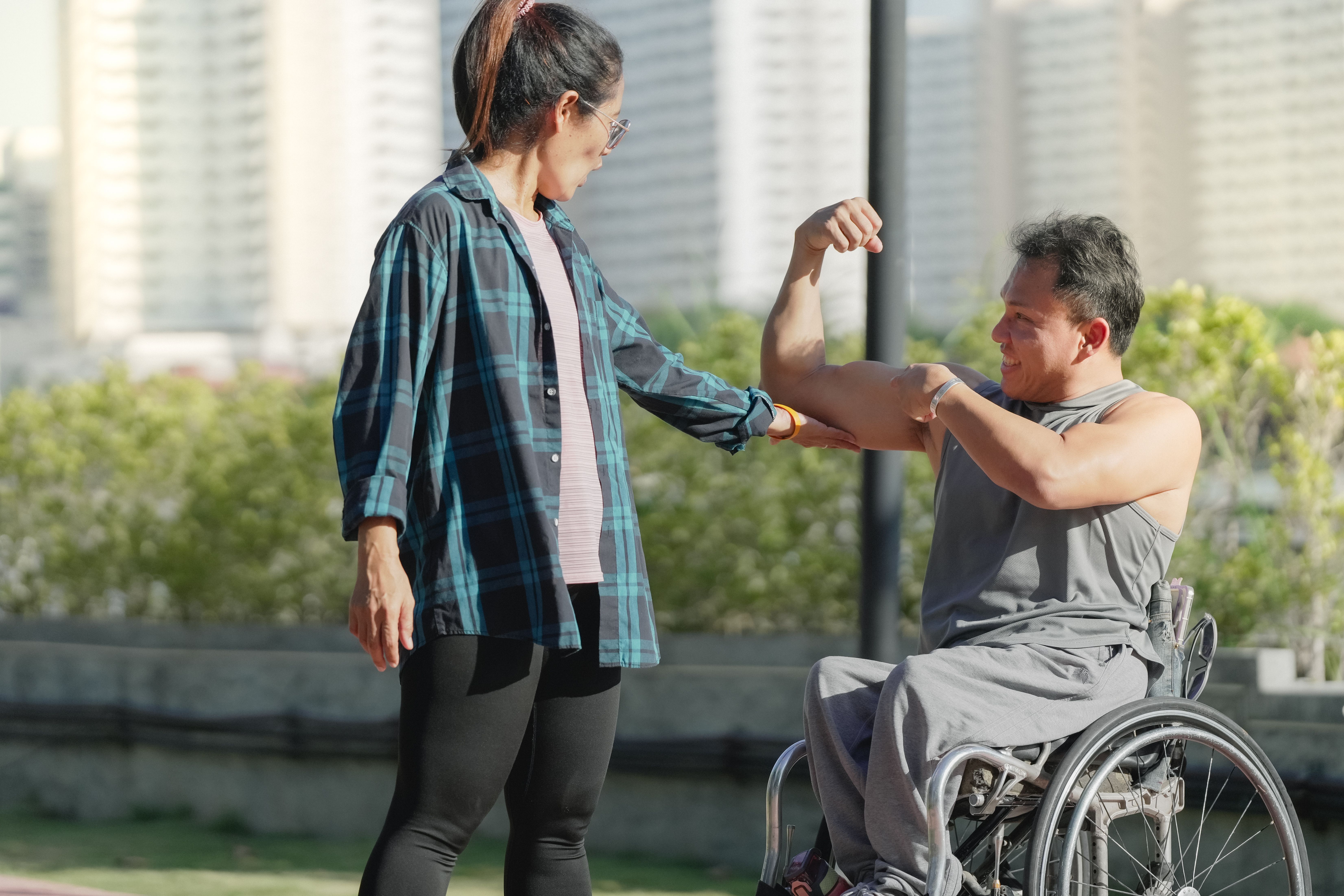 Man with muscular dystrophy in wheelchair flexing arm muscle | Image Credit: © Montri - stock.adobe.com