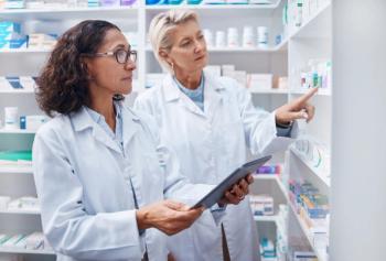 Two pharmacists in a pharmacy -- Image credit: Nina Lawrenson/peopleimages.com | stock.adobe.com