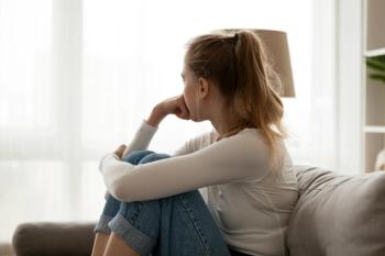 Side view young woman looking away at window sitting on couch at home. Frustrated confused female feels unhappy problem in personal life quarrel break up with boyfriend or unexpected pregnancy concept - Image credit: fizkes | stock.adobe.com