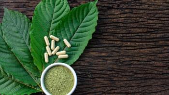 Mitragyna speciosa or kratom leaves with medicinal products in capsules and powder in white ceramic bowl and wooden table, top view | Image Credit: ©Yanawut Suntornkij - stock.adobe.com