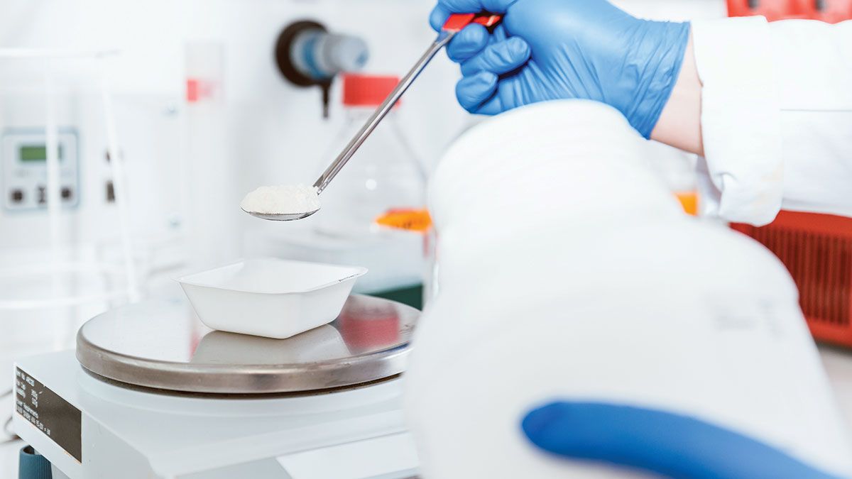 Pharmacist pouring white powdered chemical | Image Credit: @Kzenon- stock.adobe.com