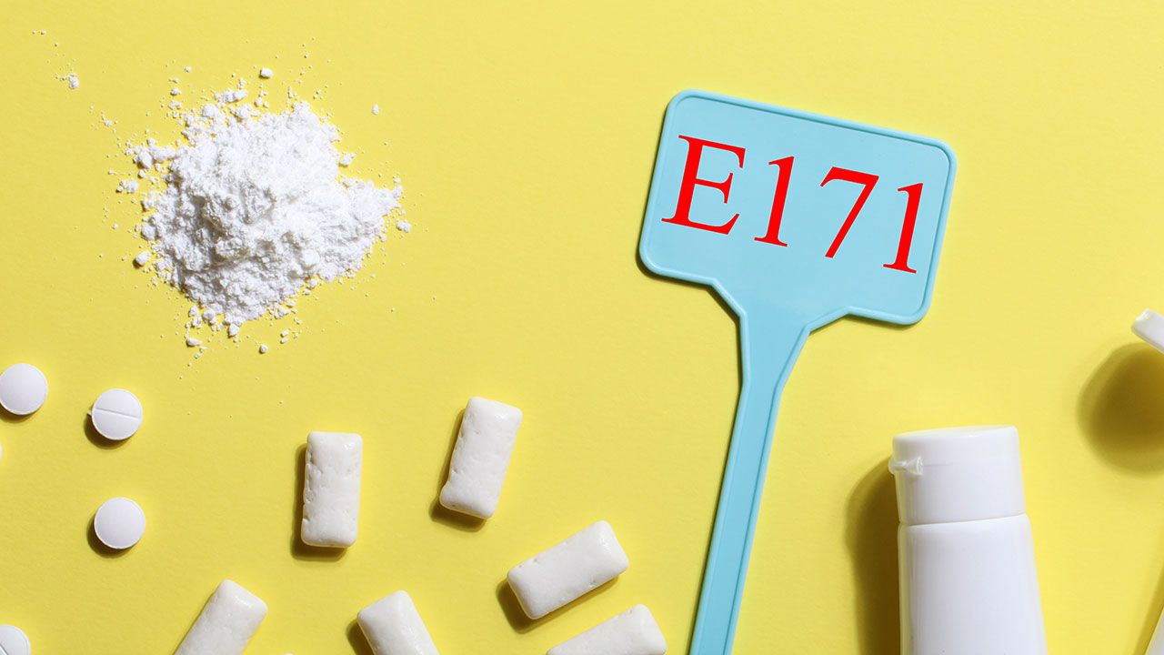 Titanium dioxide, E171, dangerous additive concept. gum, pills, toothpaste, powder and sign with E171 on yellow background. copy space banner | Image credit: ©Анна Мартьянова - stock.adobe.com