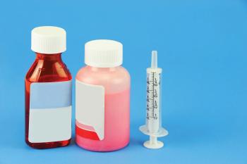 Prescription medicine bottle and oral syringe for baby isolated on blue background | Image Credit: © nd700 - stock.adobe.com
