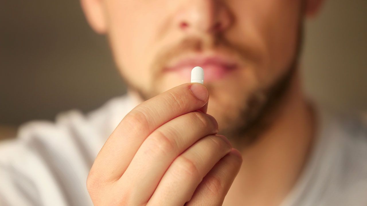 Hand of young man with pill, closeup. Image Credit: ©Africa Studio - stock.adobe.com