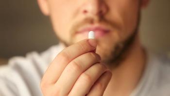 Hand of young man with pill, closeup. Image Credit: ©Africa Studio - stock.adobe.com