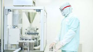 Worker operating pharma capsule filling machine | Image Credit: ©Kadmy - stock.adobe.com