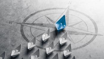 Blue Paper Boat Leading A Fleet Of Small White Boats With Compass Icon On Grey Concrete - Leadership Concept | Image Credit: ©Philip Steury -stock.adobe.com