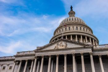 low angle view of marble dome of United States Capitol building in Washington DC with blue sky and visible architecture features | Image Credit: © Philip - stock.adobe.com