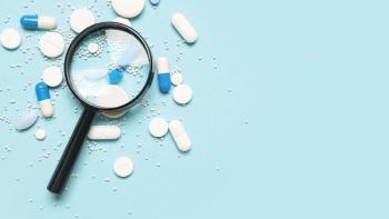 Magnifier with pills on blue background | Image Credit: © Pixel-Shot - stock.adobe.com
