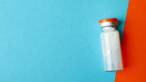 Vial with powder vaccine on two tone background | Image Credit: © Atlas - Stock.adobe.com