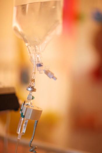 Intravenous therapy; drip chamber in focus against a colorful background | Image Credit: ©Anna Jurkovska -stock.adobe.com