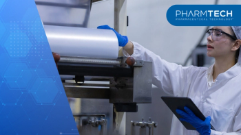 female worker wearing uniform inside factory clean room conducting inspection on manufacturing machine holding digital tablet monitor process carefully | Image Credit: ©eakgrungenerd -stock.adobe.com