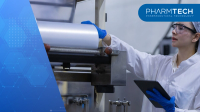 female worker wearing uniform inside factory clean room conducting inspection on manufacturing machine holding digital tablet monitor process carefully | Image Credit: ©eakgrungenerd -stock.adobe.com