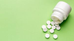 Round white pills and plastic pill bottle | Image Credit: © ironstealth - Stock.Adobe.com