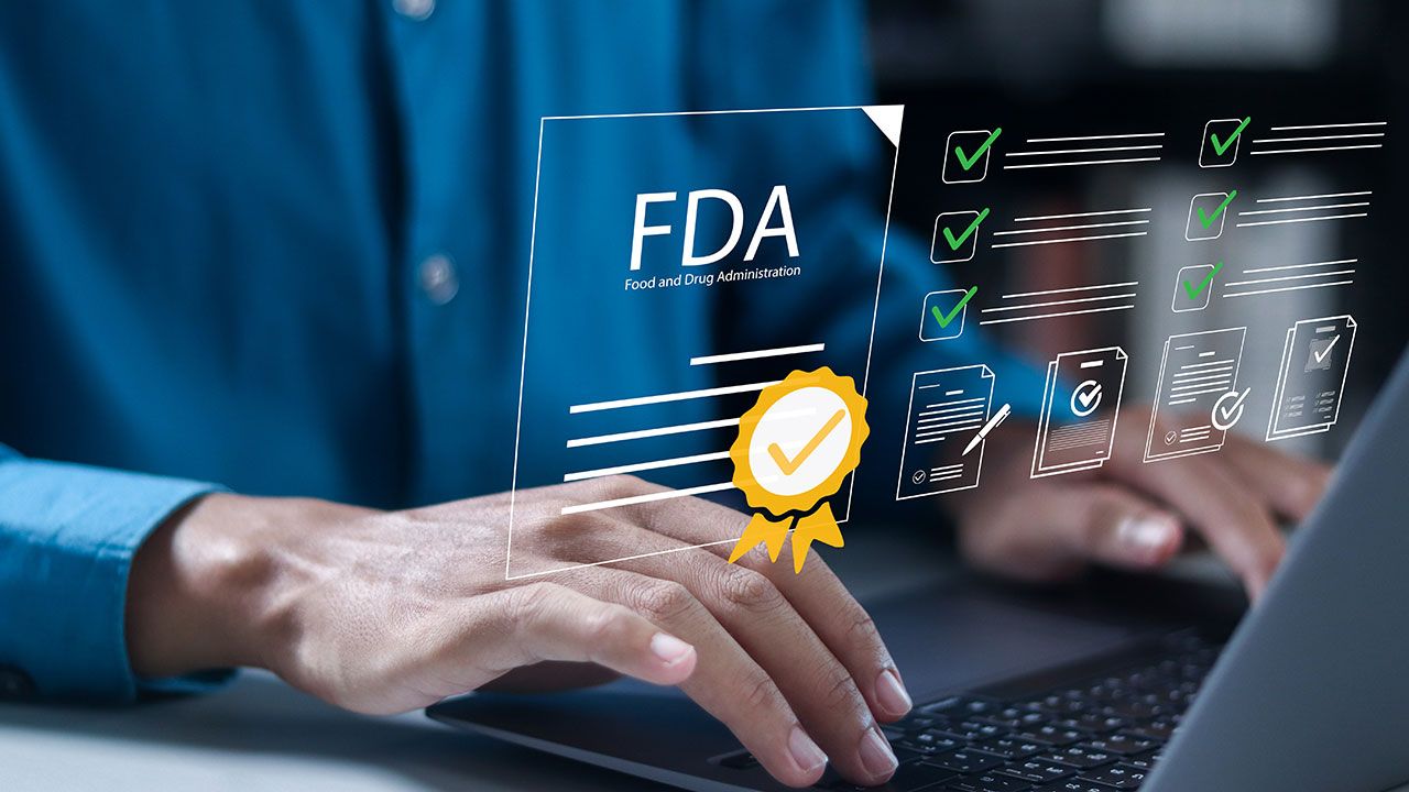 FDA, Approved Food and Drug Administration concept. Quality, certification, health product standards control system. Businessman manages pharmaceutical quality documents. | Image Credit: ©Pakin -stock.adobe.com