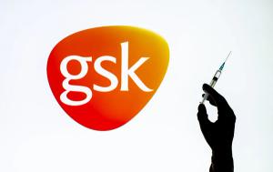 Kyiv, Ukraine - December 22, 2020: Backlit single shot image of GlaxoSmithKline logo on tv screen with a hand holding an Covid-19 vaccine concept | Image Credit: © Олександр Луценко - stock.adobe.com