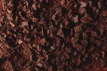 Flat lay view of dark chocolate chopped. Texture of cracked chocolate with copy space. | Image Credit: © Elena Uve - stock.adobe.com