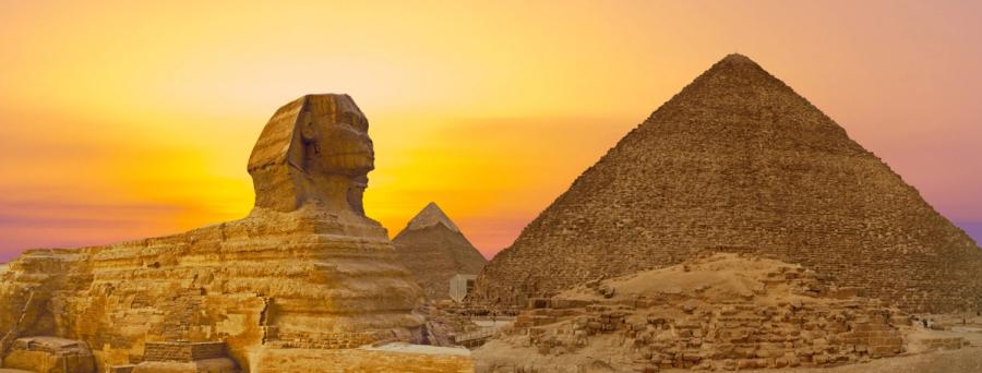 Great Pyramid and Sphinx against an orange sunset