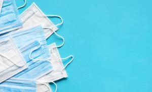 disposable masks lined up on a blue background