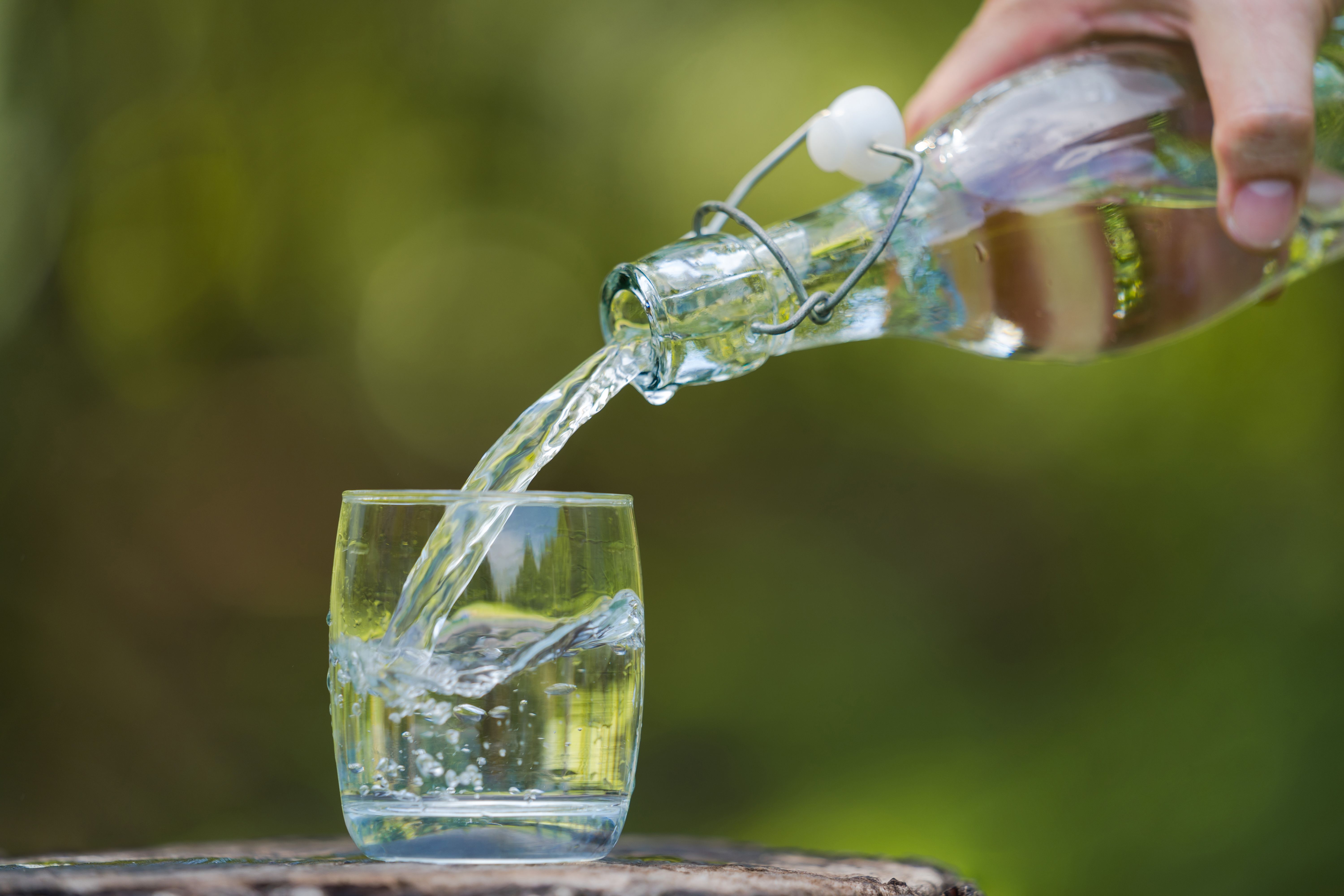 Hand pouring drink water from bottle into glass with natural background | Image Credit: © Naypong Studio - stock.adobe.com
