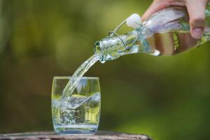 Hand pouring drink water from bottle into glass with natural background | Image Credit: © Naypong Studio - stock.adobe.com