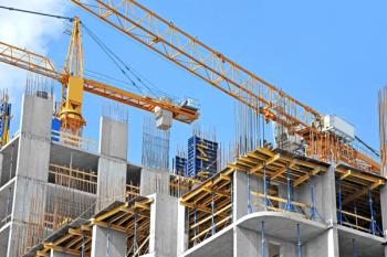 Crane and building construction site against blue sky | Image Credit: © Unkas Photo - stock.adobe.com.