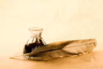 Feather and ink bottle isolated on paper background | Image Credit: © Sergey Yarochkin - stock.adobe.com