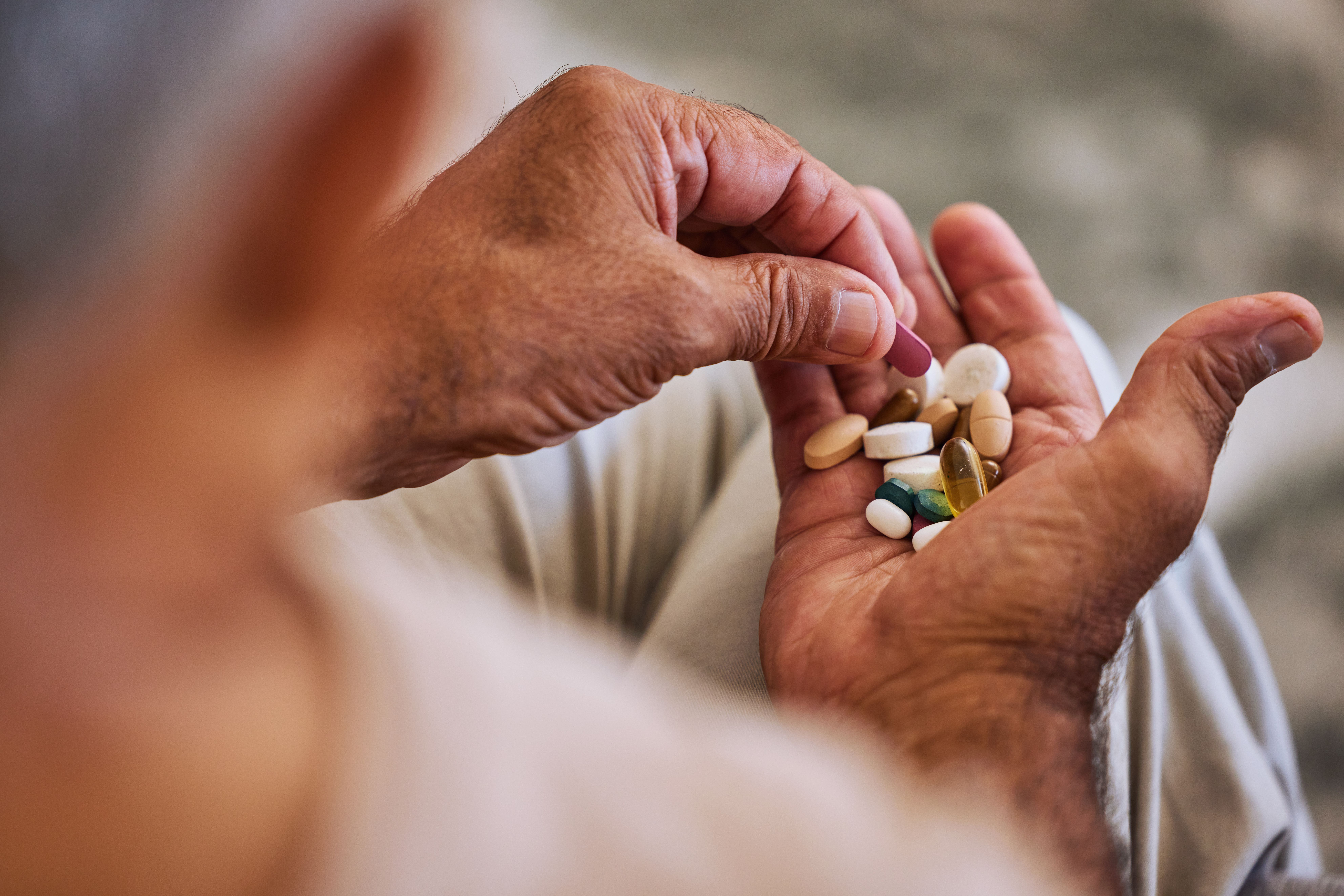 Pills, medicine, and healthcare of senior man taking daily capsules for chronic illness, cancer or health. Wellness, medication and sick elderly with medical drugs, vitamins or supplements in his hand. | Image Credit: © Beaunitta Van Wyk/peopleimages.com - stock.adobe.com