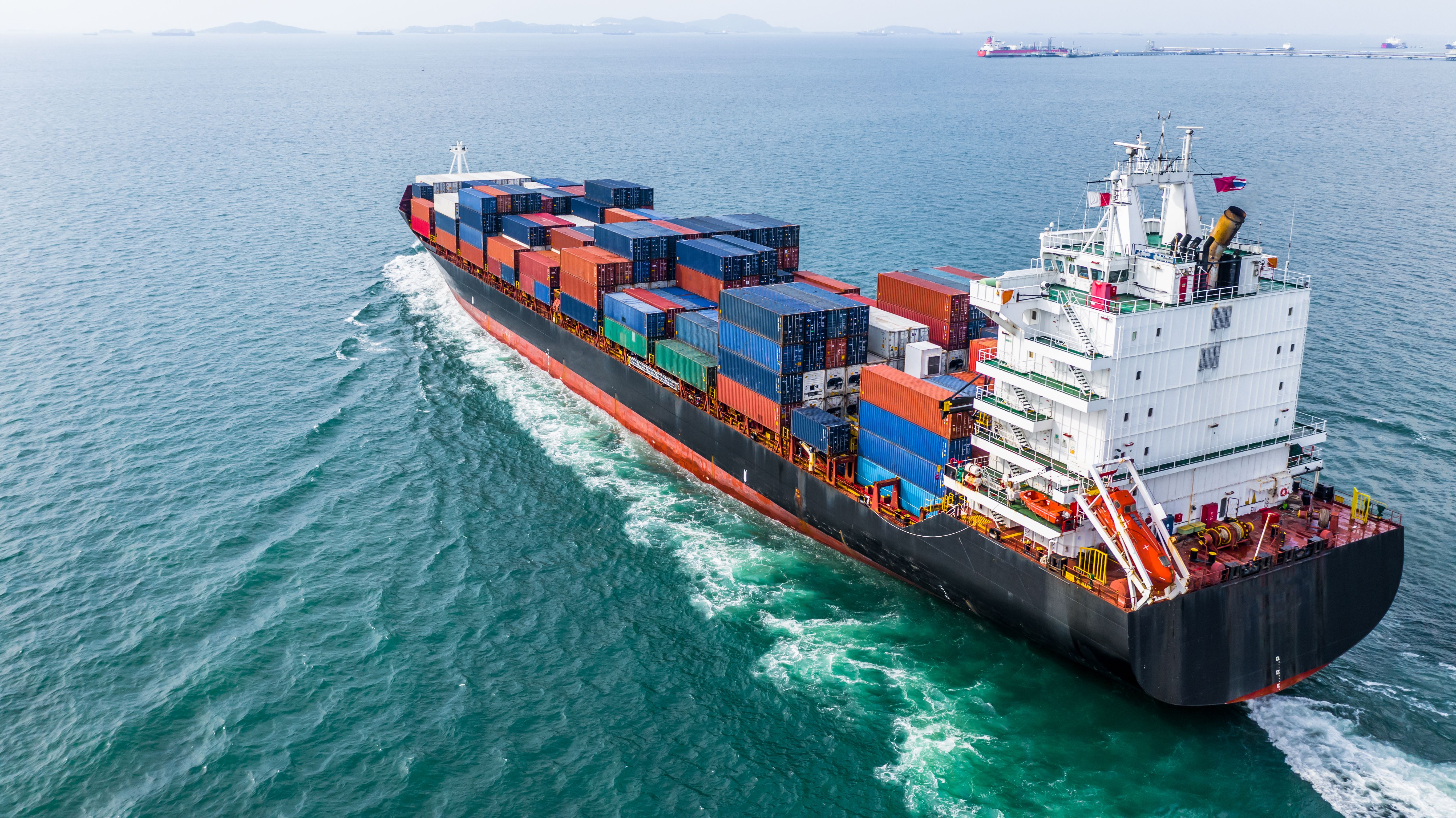 Aerial view cargo container ship sailing, container cargo ship in import export and business logistic and transportation of international by container ship, view from above business background | Image Credit: © Kalyakan - stock.adobe.com