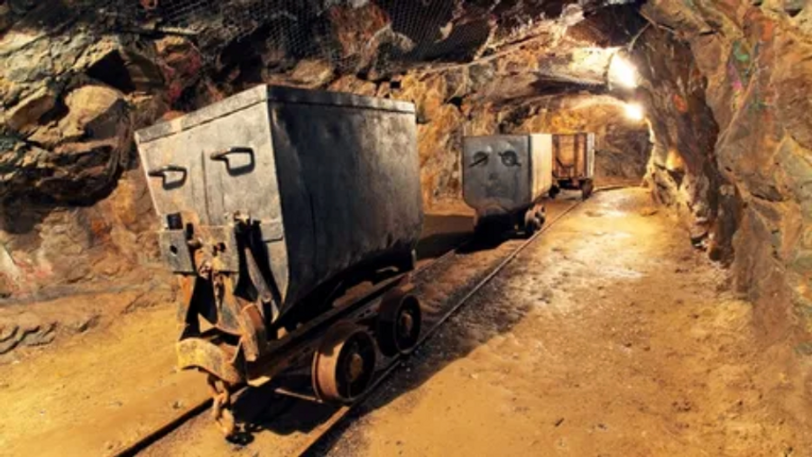 mine carts going down a metal track into a mine