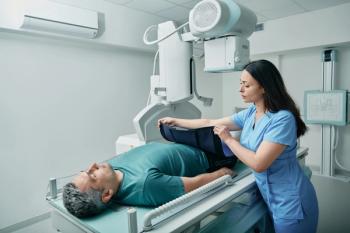 Female technician preparing patient for body X-ray in radiographic imaging room, putting for him radiation protection apron | Image Credit: © Peakstock - stock.adobe.com