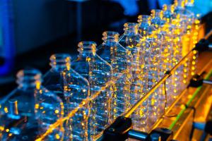 Bottle. Industrial production of plastic pet bottles. Factory line for manufacturing polyethylene bottles. Transparent food packaging. | Image Credit: © salomonus_ - stock.adobe.com