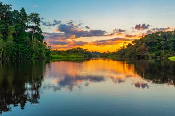 Reflection of a sunset by a lagoon inside the Amazon Rainforest Basin. The Amazon river basin comprises the countries of Brazil, Bolivia, Colombia, Ecuador, Guyana, Suriname, Peru and Venezuela. | Image Credit: © SL-Photography - stock.adobe.com