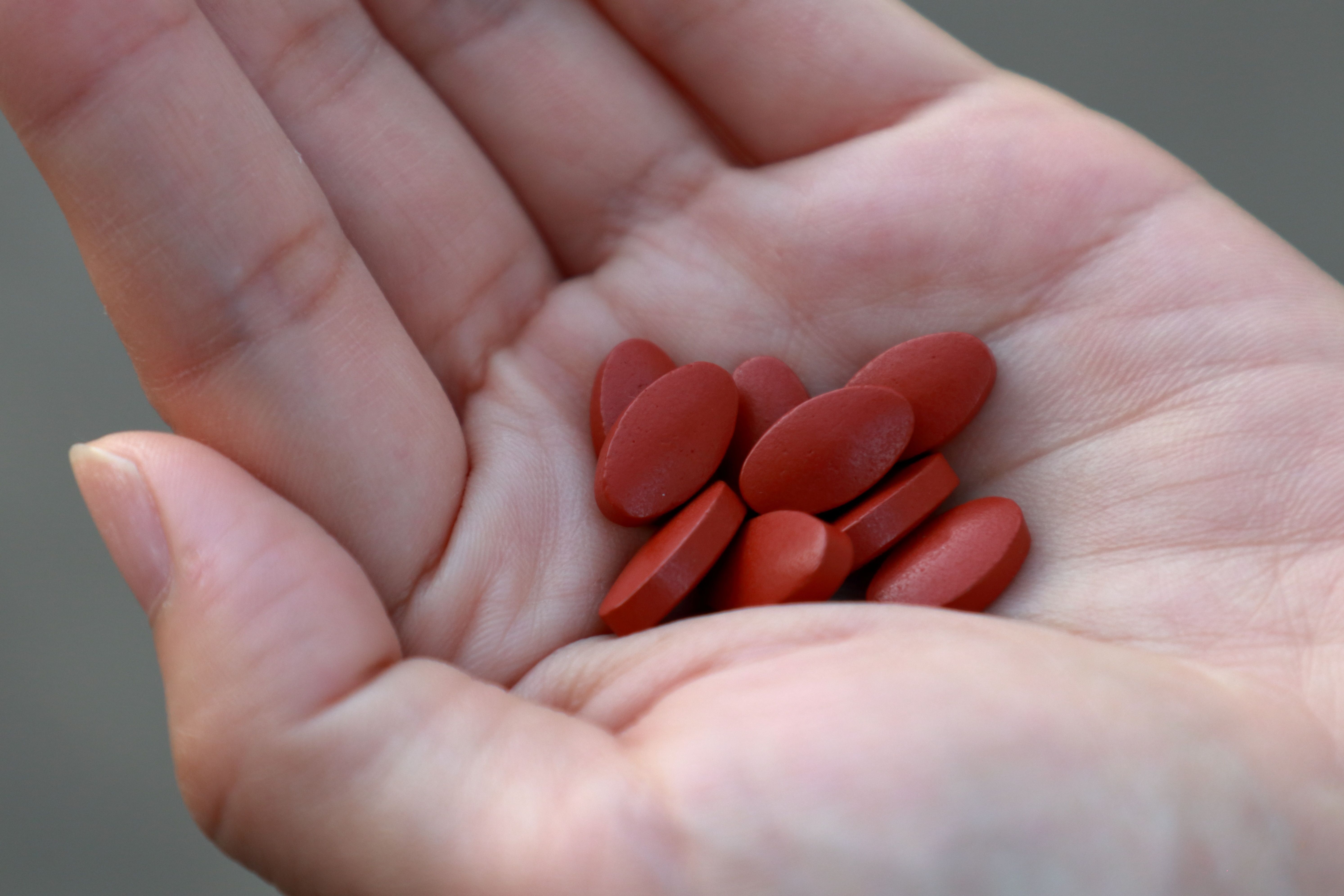 Iron supplement tablets in woman’s hand for treating iron deficiency anemia. | Image Credit: agencies - stock.adobe.com