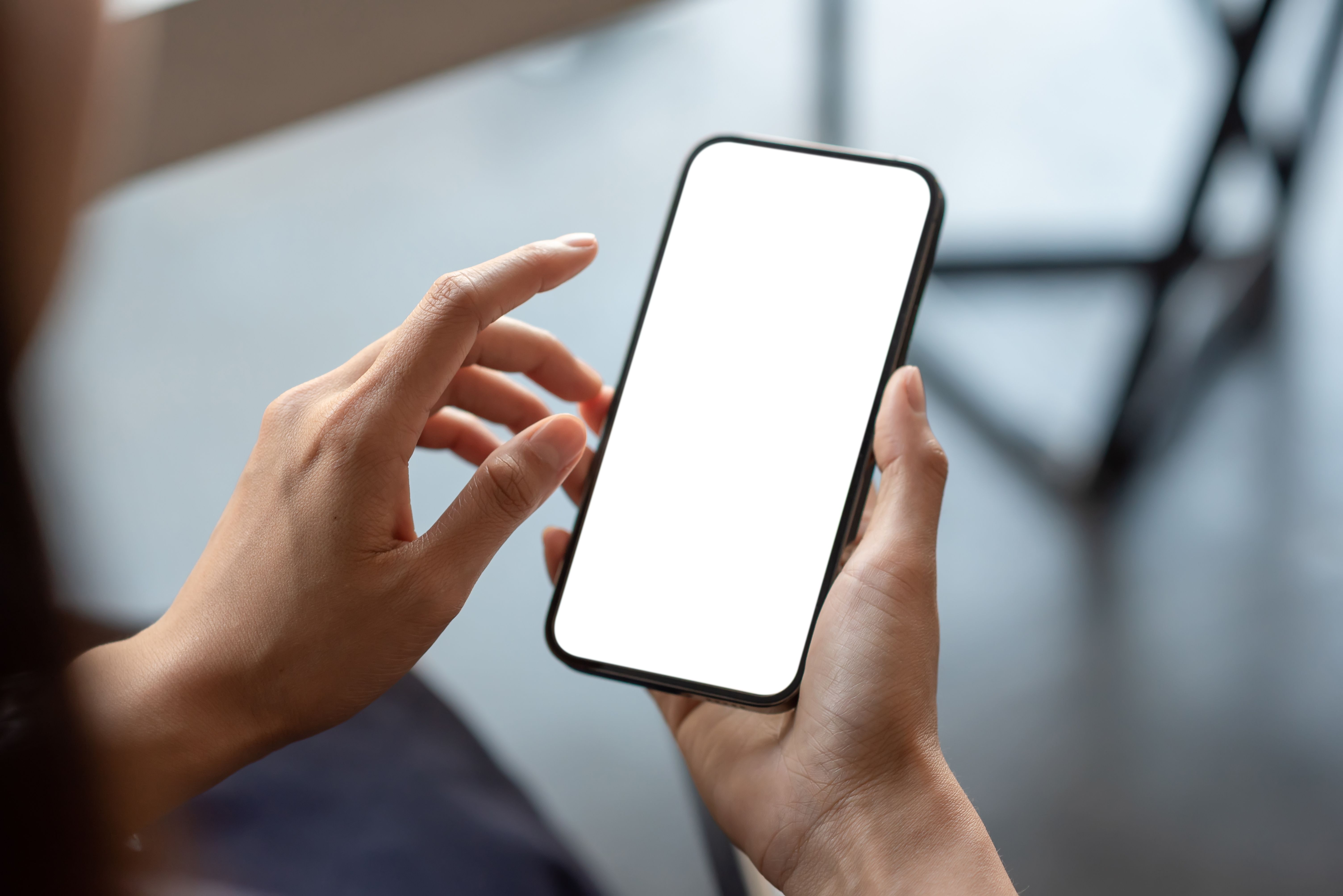 Close-up of a businessman hand holding a smartphone white screen is blank the background is blurred. | Image Credit: © amnaj - stock.adobe.com