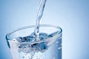 Pouring water into glass on blue background | Image Credit: © Hyrma - stock.adobe.com.