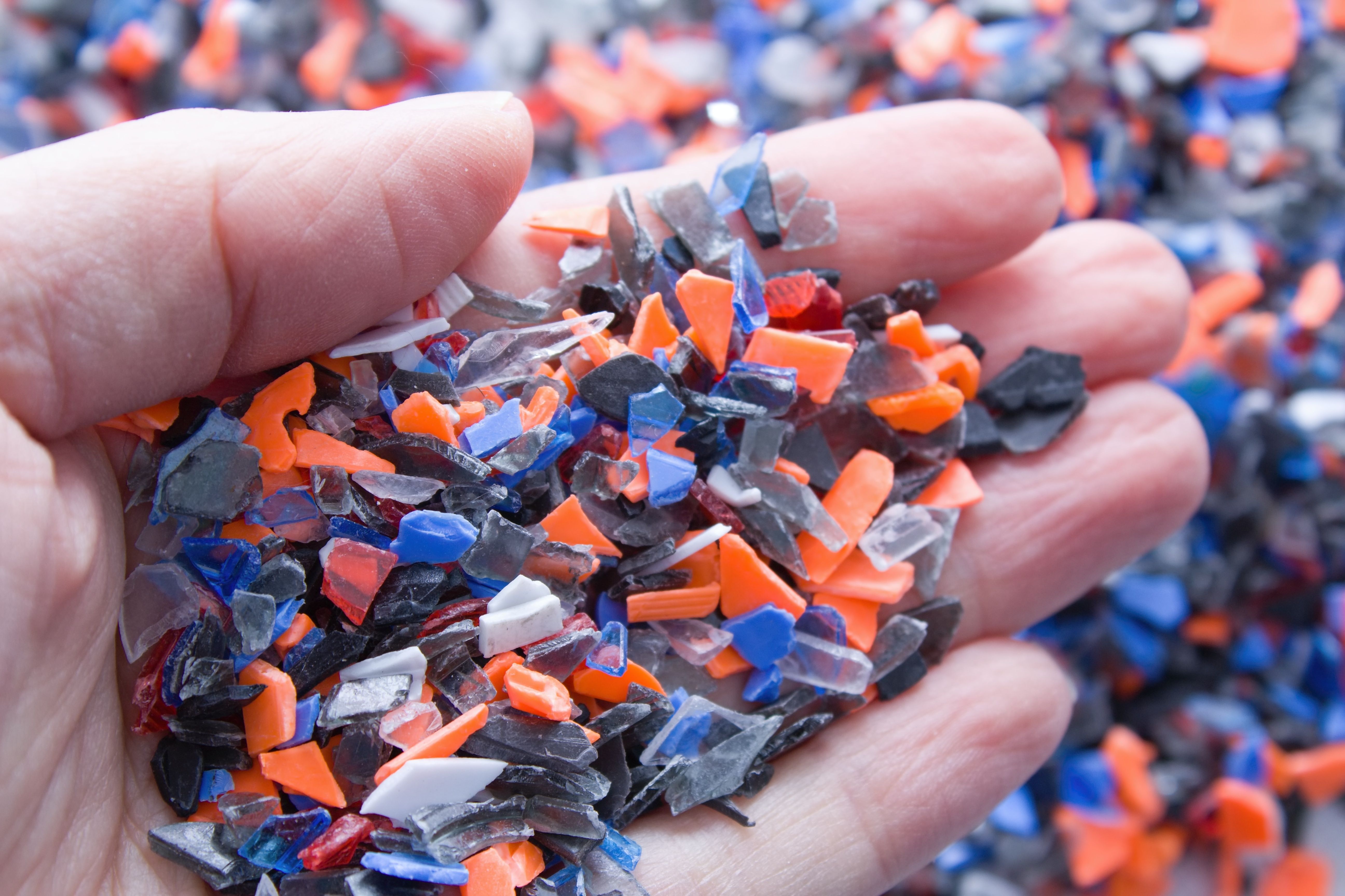 A pile of microplastics - small pieces of hard plastic on palm, intended for further processing. | Image Credit: © luckakcul - stock.adobe.com.