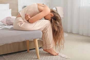 Young woman suffering from abdominal pain at home | Image Credit: © Pixel-Shot - stock.adobe.com