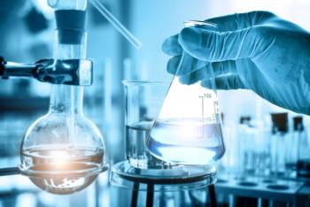 Hand of scientist holding flask with lab glassware in chemical laboratory background. Science laboratory research and development concept. | Image Credit: © totojang1977 - stock.adobe.com