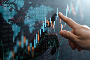 Graphs and world financial markets data. Investor pointing at the candlestick chart. | Image Credit: © tadamichi - stock.adobe.com.