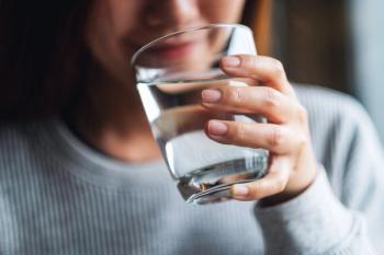 Closeup image of a young woman holding a glass of water to drink. | Image Credit: © Farknot Architect - stock.adobe.com